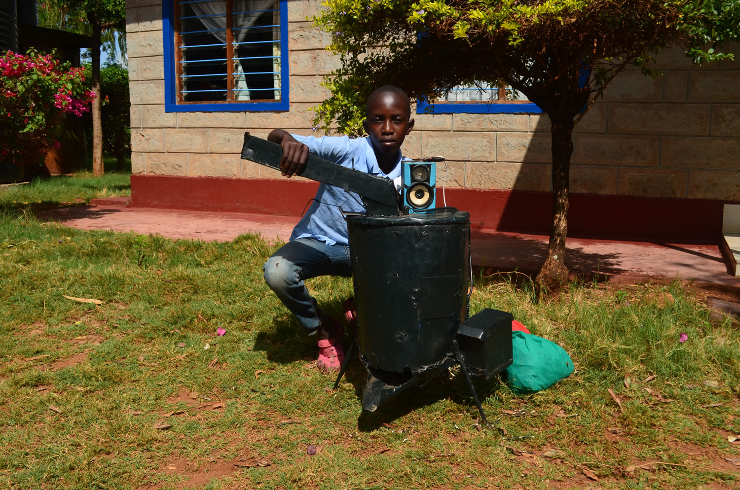 A young talented man displays an improvised green grams winowing machine