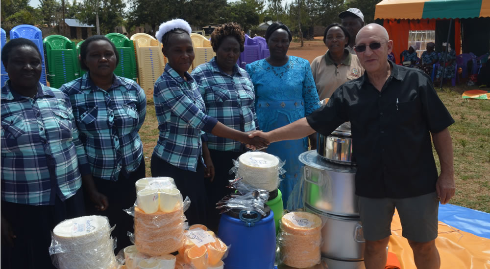 Donor Issuing Cooking Utensils to Neighbors Women Group